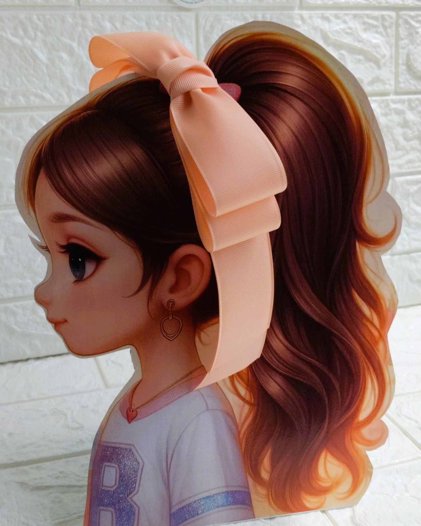 Illustration of a girl with brown hair in pigtails wearing a TinyShiny Bow Peach color