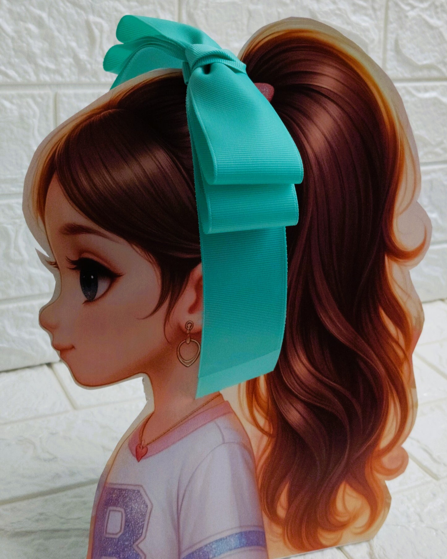Illustration of a girl with brown hair in pigtails wearing a TinyShiny Bow Aqua color 