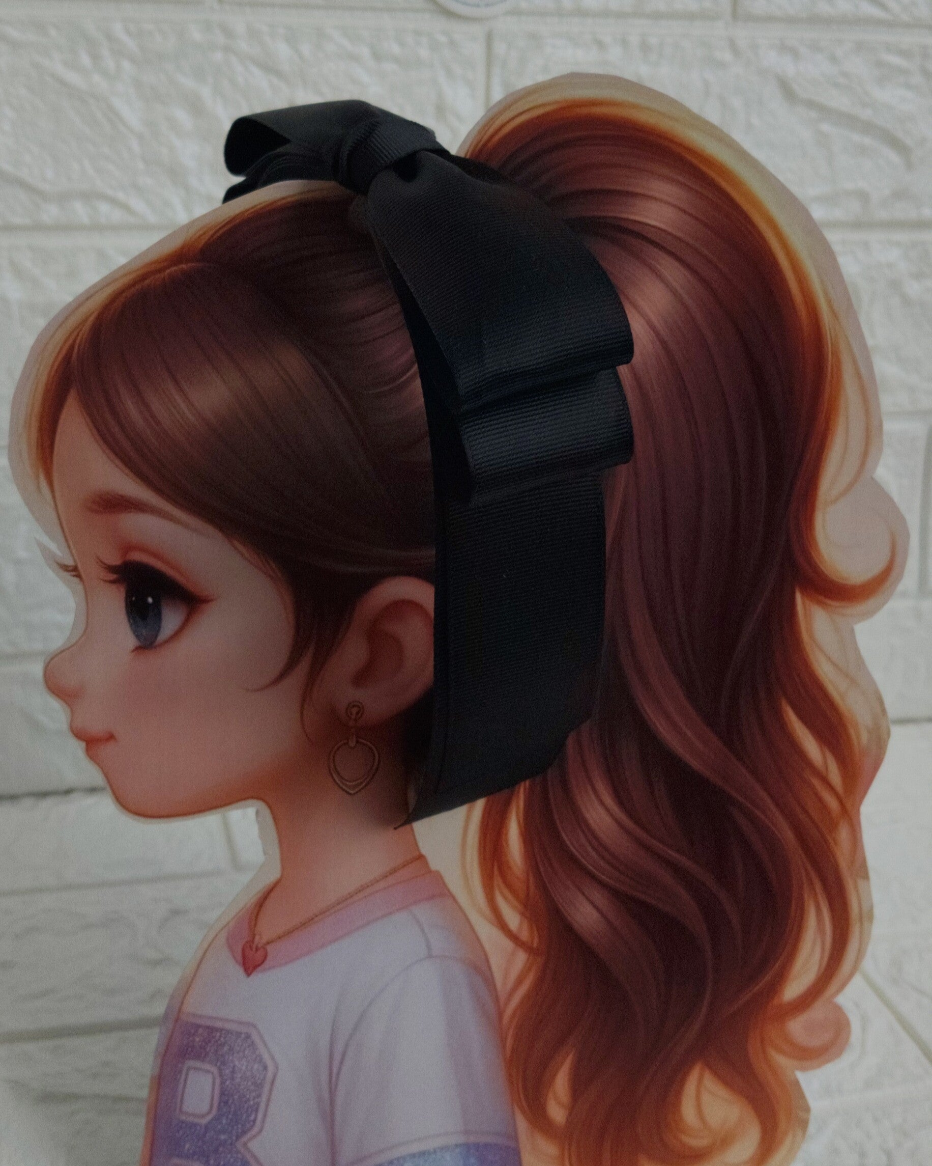 Illustration of a girl with brown hair in pigtails wearing a TinyShiny Bow Black color 
