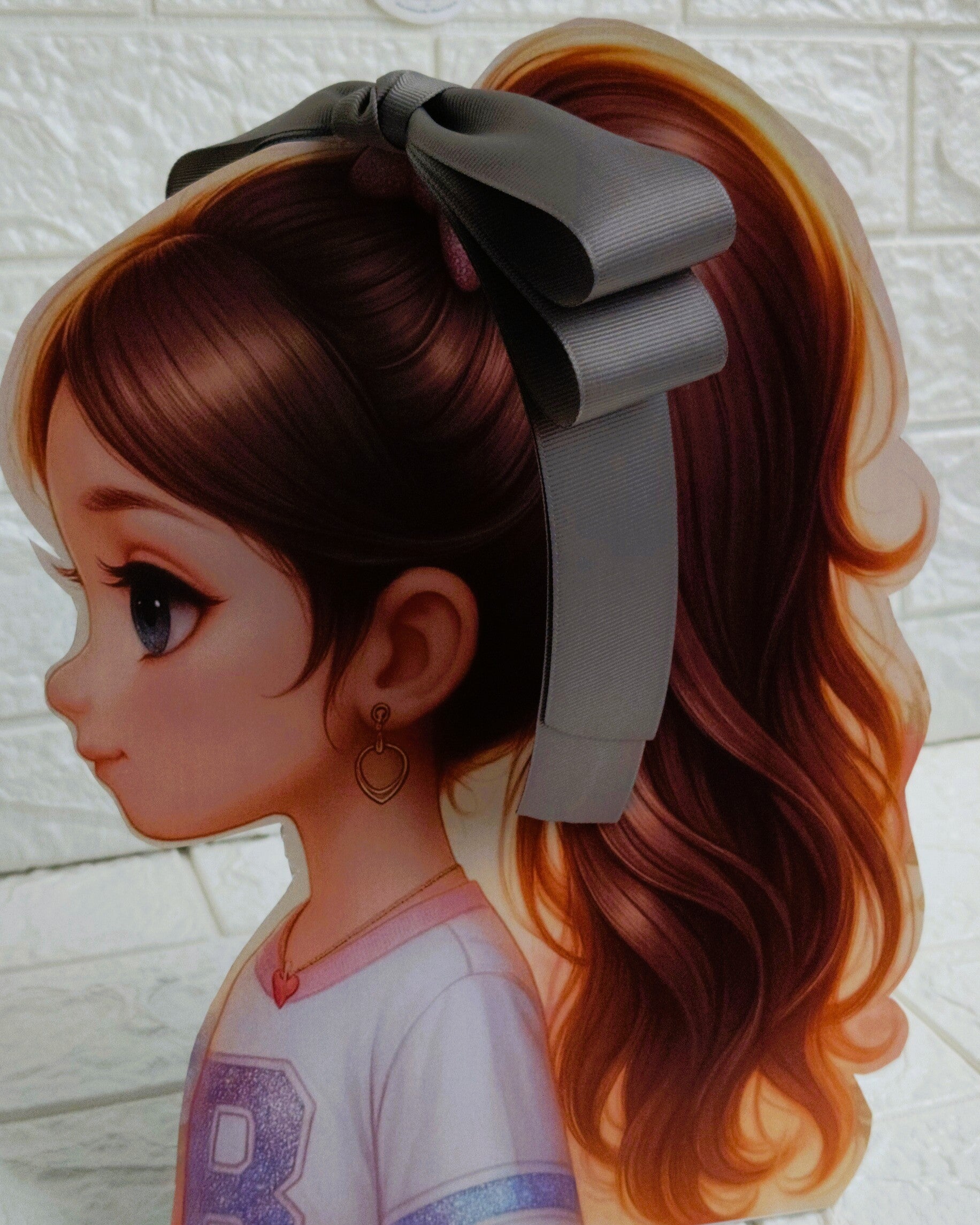 Illustration of a girl with brown hair in pigtails wearing a TinyShiny Bow Grey color 