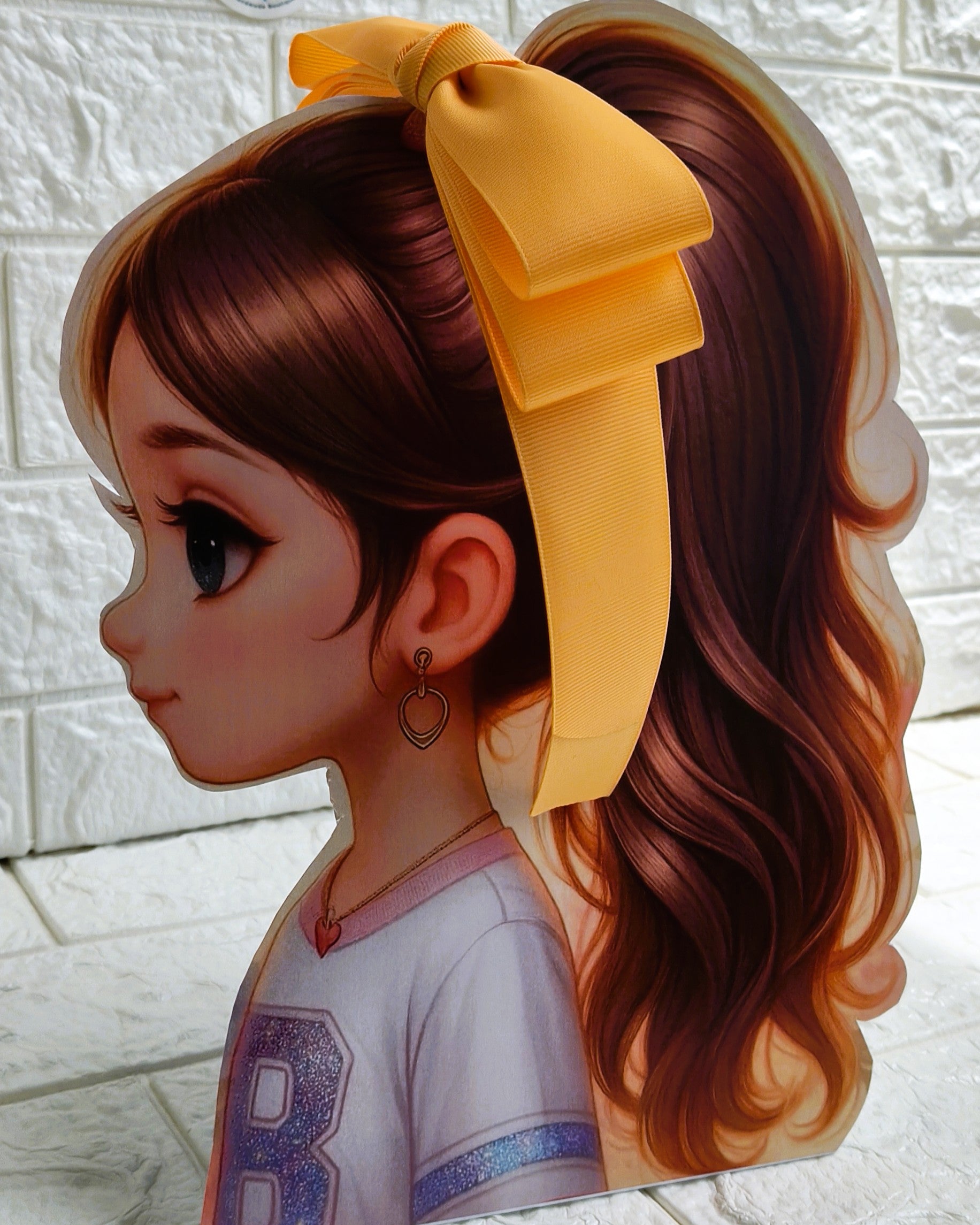 Illustration of a girl with brown hair in pigtails wearing a TinyShiny Bow Marigold color 
