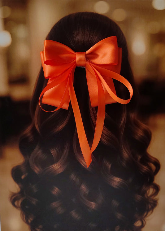 Back view of a girl with long curled hair wearing a large bright orange satin bow - perfect for festive or formal occasions - TinyShiny